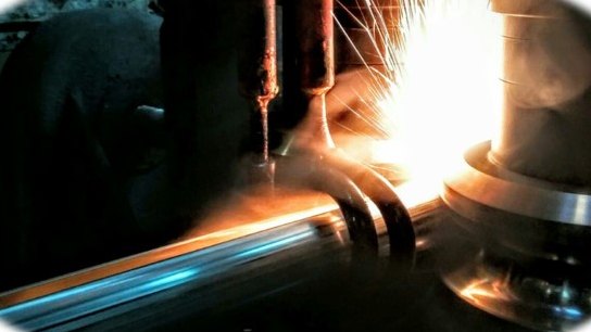 High-frequency induction welding a tube seam, sparks at the weld point